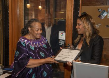 Dawn Moore presents Joe Manns Black Wall St. Award to Margaret Powell, a longtime advocate in the Matthew Henson community in West Baltimore.