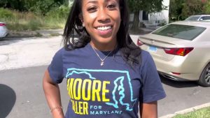 Kennedi Riley helps Wes Moore distribute water in Harlem Park