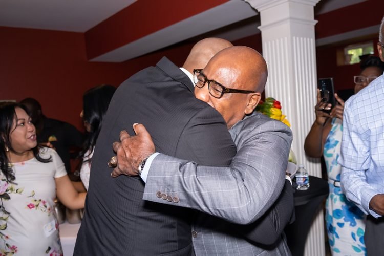 Morgan State University President Dr. David Wilson embraces Wes during a recent fundraiser at the home of Dr. Tyrone Taborn.